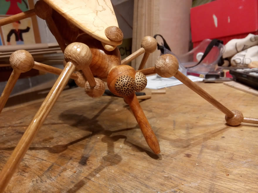 My next mosquito and signature trademark! Made from yew (body), oak (legs and eyes), and hornbeam (wings), this is intended to be a female Anopheles gambiae - the most deadly malaria spreading mosquito in the world! I modified the design using little turned balls for the leg-joints, which makes them much stronger. I used pyrography to dot the eyes.